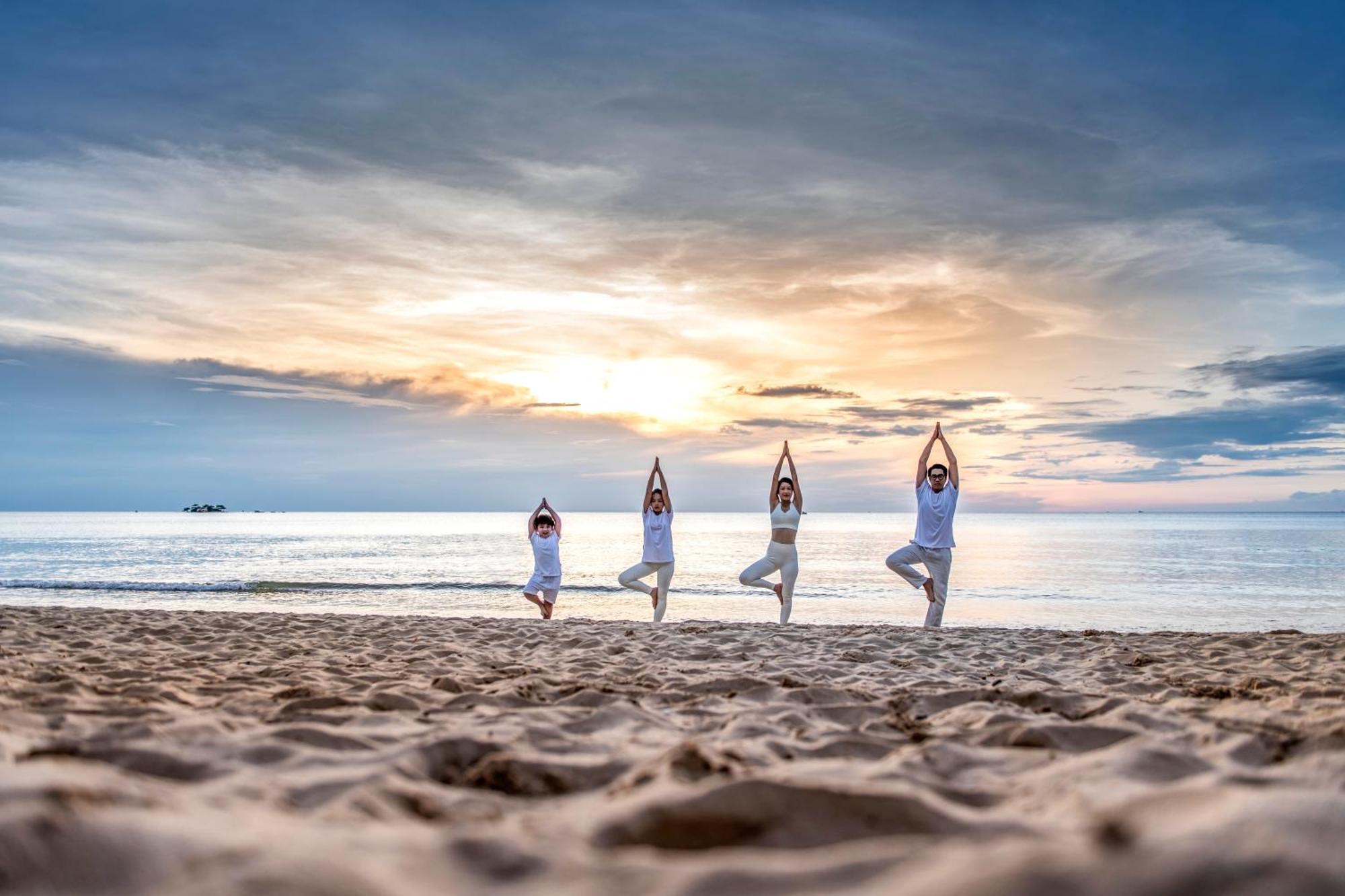 Vinpearl Resort & Spa Phu Quoc Bagian luar foto Family practicing yoga on the beach